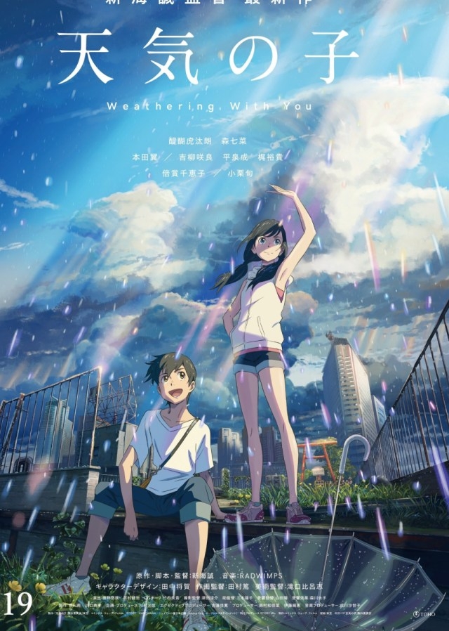 Hodaka Morishima and Hina Amano stand together in the rain, with Hina raising her hand towards the sky, in the official movie poster for Makoto Shinkai's "Weathering With You."