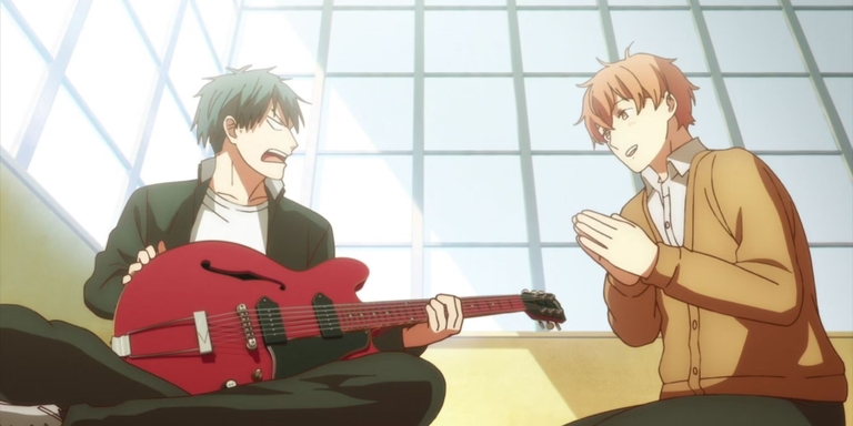Ritsuka Uenoyama looking surprised while holding Mafuyu Sato's Gibson ES-330 guitar, with Mafuyu smiling beside him, in a scene from the anime series Given.